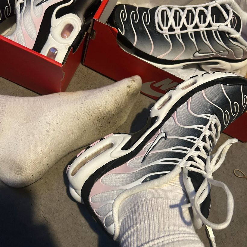 A worn white sock next to new Nike trainers in the box